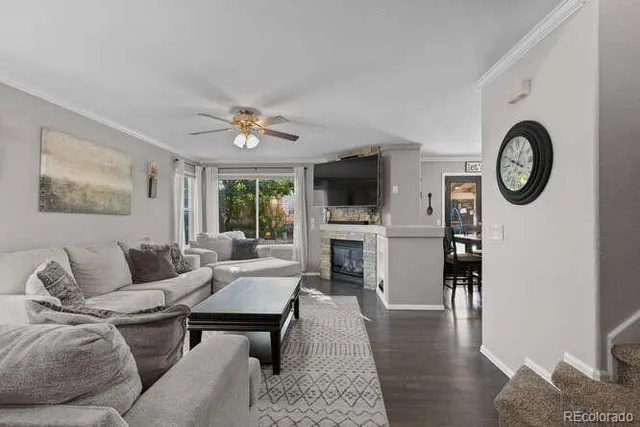 a living room with furniture a fireplace and wooden floor