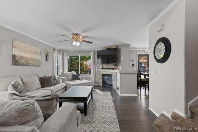 8354 Dove Ridge Way Parker, CO 80134 - Photo 7 of 38 a living room with furniture a fireplace and wooden floor