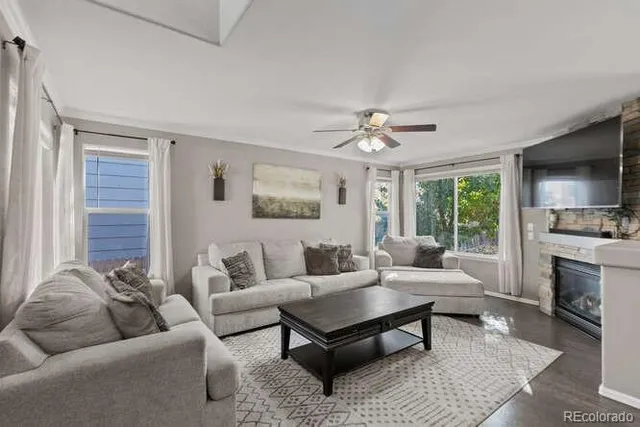 a living room with furniture a large window and a fireplace