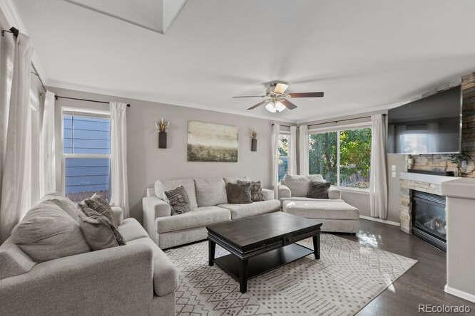 8354 Dove Ridge Way Parker, CO 80134 - Photo 8 of 38 a living room with furniture a large window and a fireplace