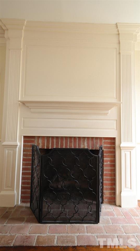 2319 Hales Road Raleigh, NC 27608 - Photo 6 of 20 a fireplace with a clock on it