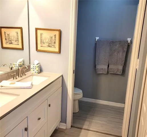a bathroom with a granite countertop sink mirror vanity and toilet