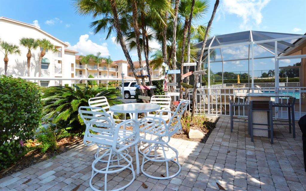 9620 Club S Circle, Unit 5105 Sarasota, FL 34238 - Photo 19 of 36 a view of a patio with table and chairs potted plants