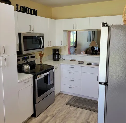 a kitchen with a sink stove and microwave