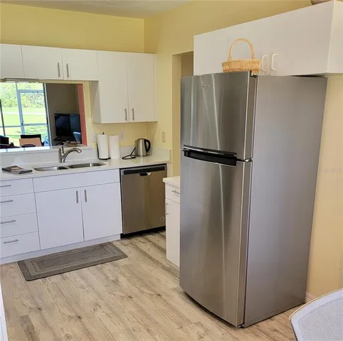 a kitchen with a refrigerator a sink and cabinets