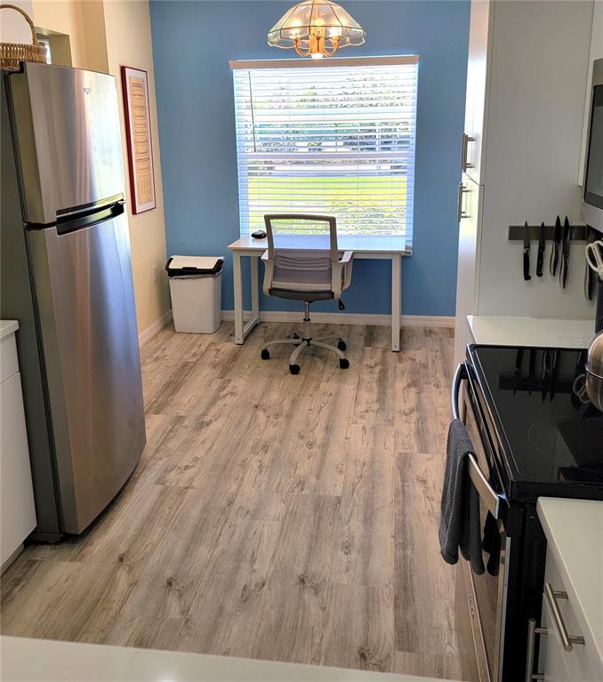 9620 Club S Circle, Unit 5105 Sarasota, FL 34238 - Photo 5 of 36 a kitchen with a refrigerator and a wooden floor