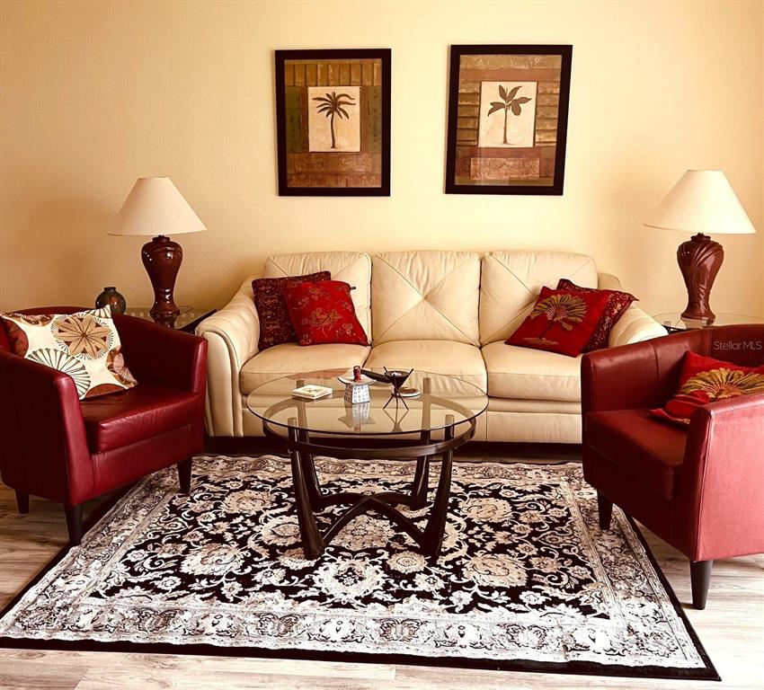 9620 Club S Circle, Unit 5105 Sarasota, FL 34238 - Photo 8 of 36 a living room with furniture wooden floor and a lamp