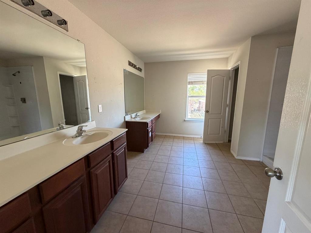 10400 Wagon Rut Court Fort Worth, TX 76108 - Photo 23 of 26 Bathroom with two vanities and light tile patterned floors