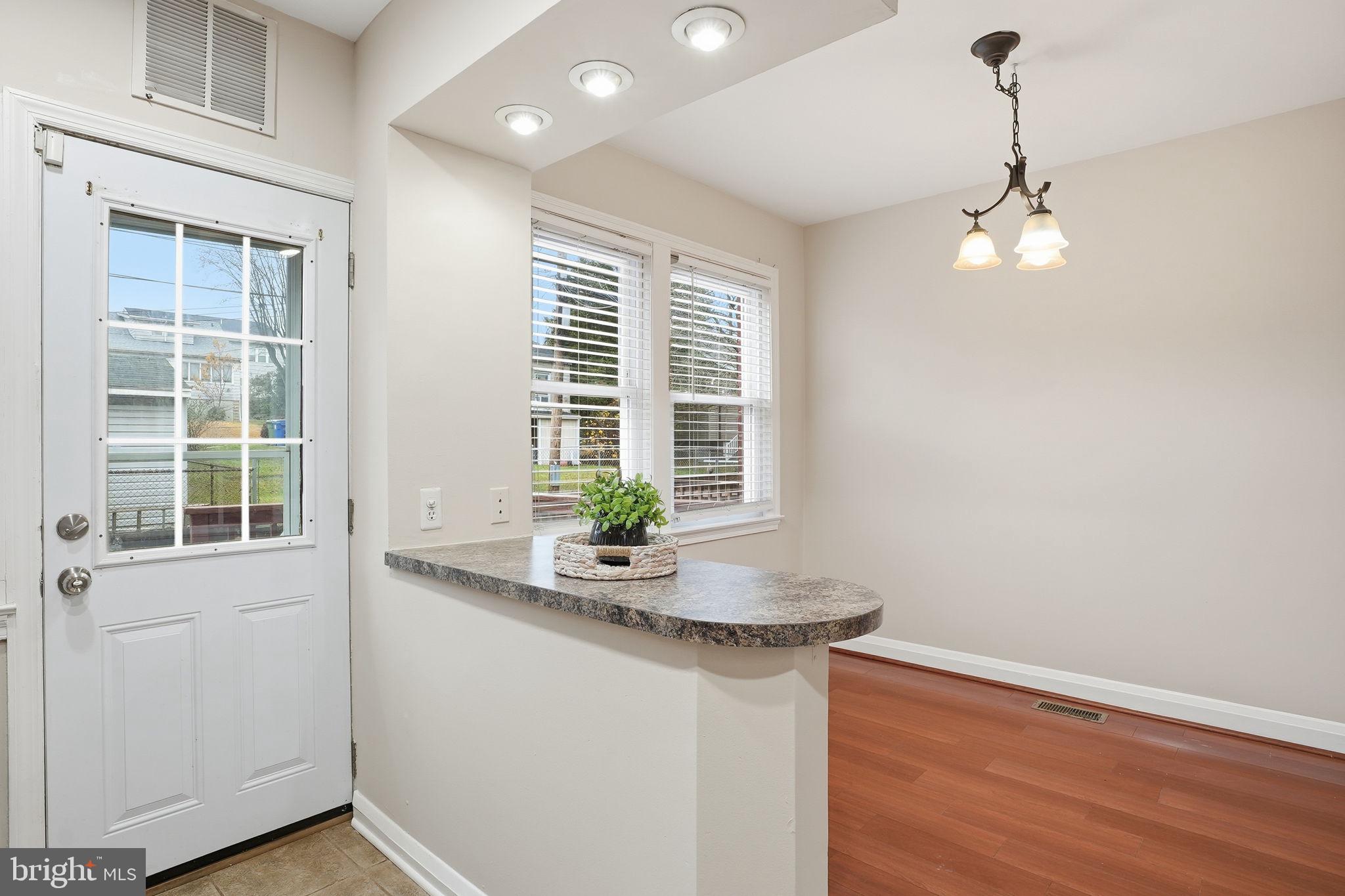 4306 Newport Avenue Baltimore, MD 21211 - Photo 11 of 44 a kitchen with stainless steel appliances granite countertop a sink a window and wooden floor