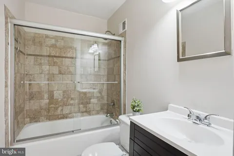 a bathroom with a sink mirror toilet and bathtub