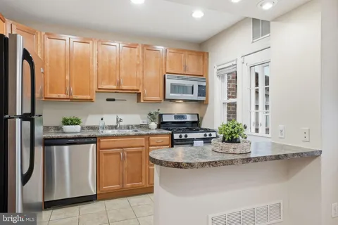 a kitchen with granite countertop a sink stove and cabinets
