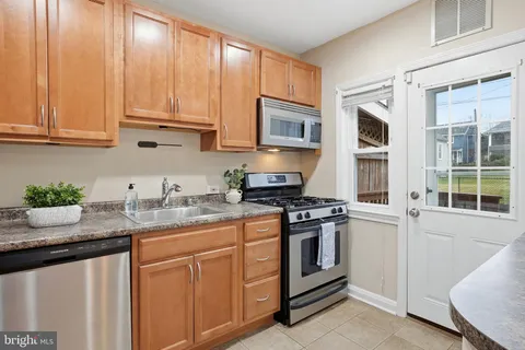 a kitchen with stainless steel appliances granite countertop a sink stove and cabinets
