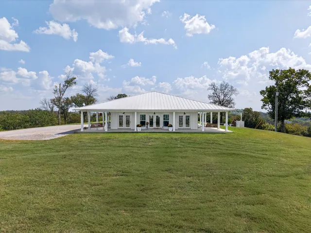 a living room with furniture a flat screen tv and kitchen view