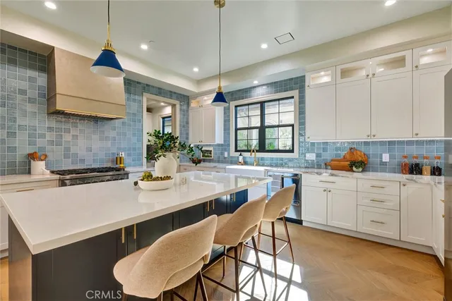 a large kitchen with a counter space a sink stainless steel appliances and cabinets