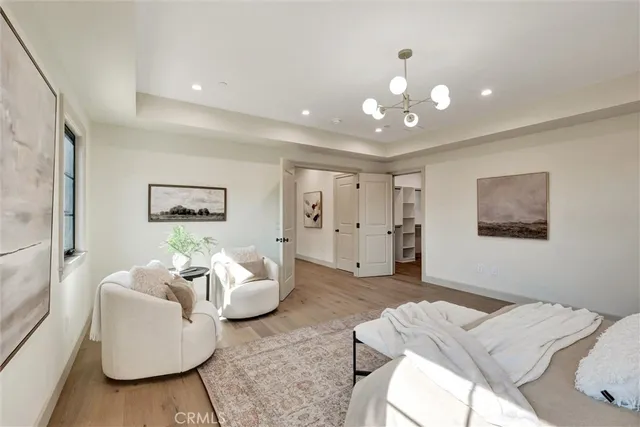 a bedroom with a bed chandelier and a window