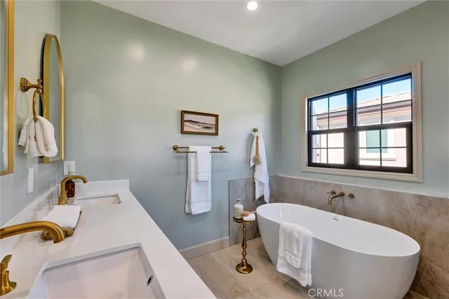 a bathroom with a granite countertop sink a mirror and a bathtub