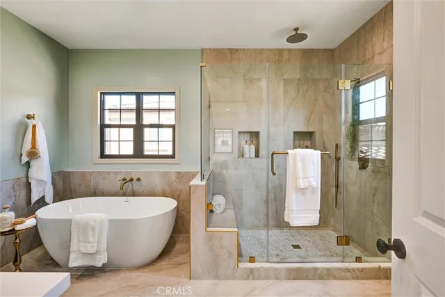 a bedroom with a large bed and windows