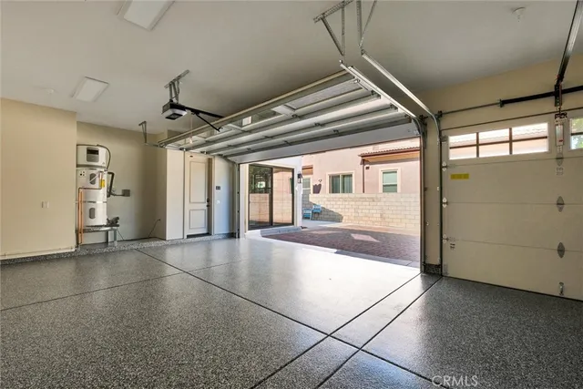 an empty room with kitchen view and wooden floor
