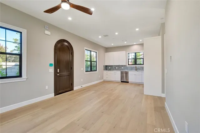 a kitchen with white cabinets appliances and a window
