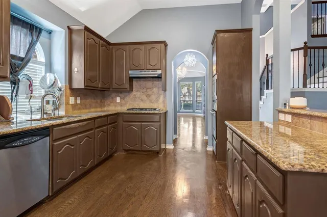 a kitchen with stainless steel appliances granite countertop a sink stove and refrigerator