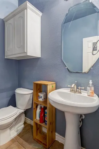 a bathroom with a sink toilet and a mirror