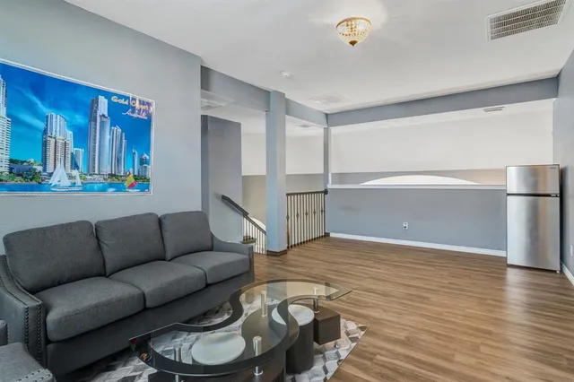 a living room with furniture and a wooden floor
