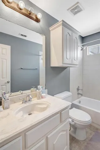 a bathroom with a granite countertop sink a toilet and a mirror