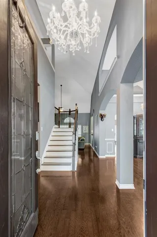 a view of a hallway with wooden floor and staircase