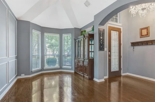 a view of a big room with wooden floor and windows
