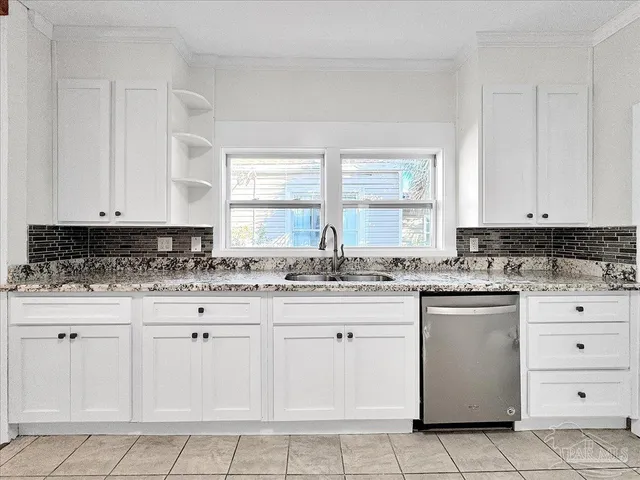 a kitchen with granite countertop white cabinets and white stainless steel appliances