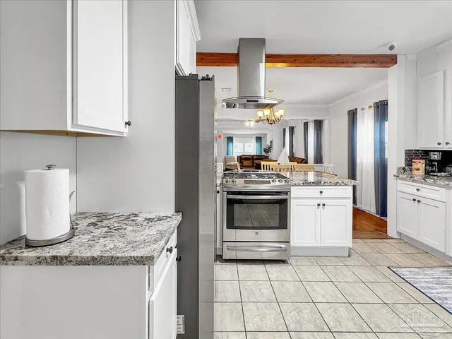 a kitchen with granite countertop a sink stove and cabinets