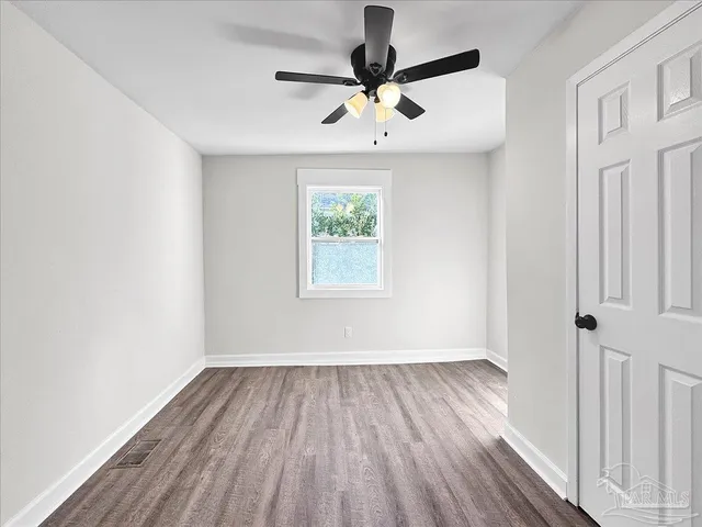 a view of room with window ceiling fan and hardwood floor