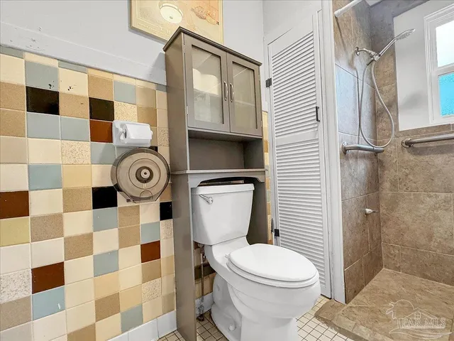 a bathroom with a toilet and a shower