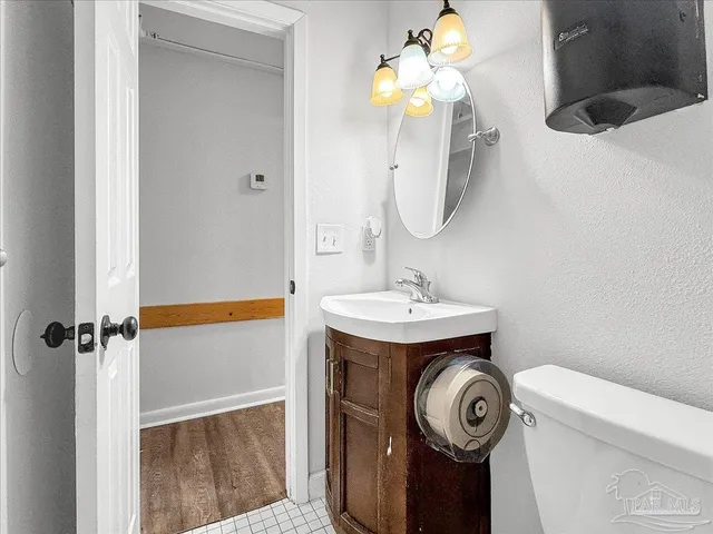 a bathroom with a sink a toilet and a mirror