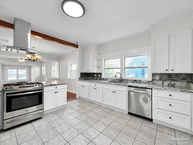 a kitchen with granite countertop white cabinets and stainless steel appliances
