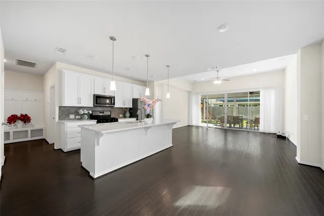 a large white kitchen with lots of counter space a sink and appliances