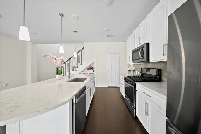 a kitchen with a sink a microwave a stove and refrigerator