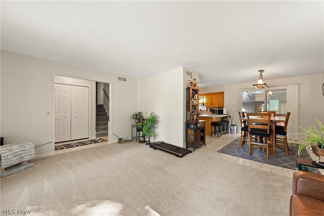 Open-concept living area with neutral carpeting