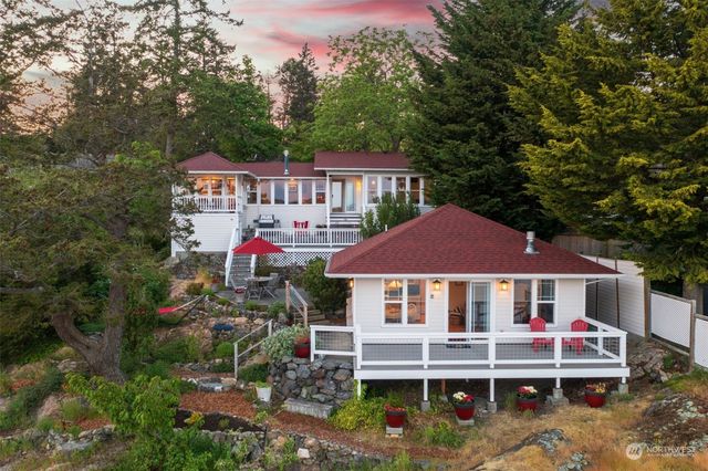 a front view of a house with a yard and lake view