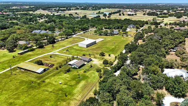 an aerial view of residential houses with outdoor space and trees