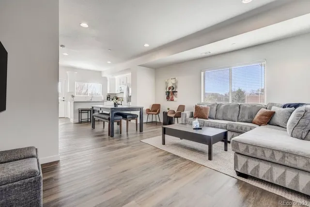 a kitchen with stainless steel appliances granite countertop a dining table chairs stove refrigerator and cabinets