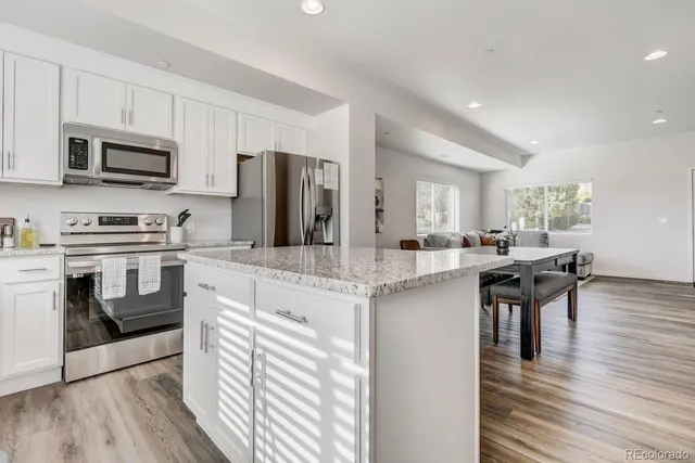 a kitchen with stainless steel appliances granite countertop a sink a stove and cabinets