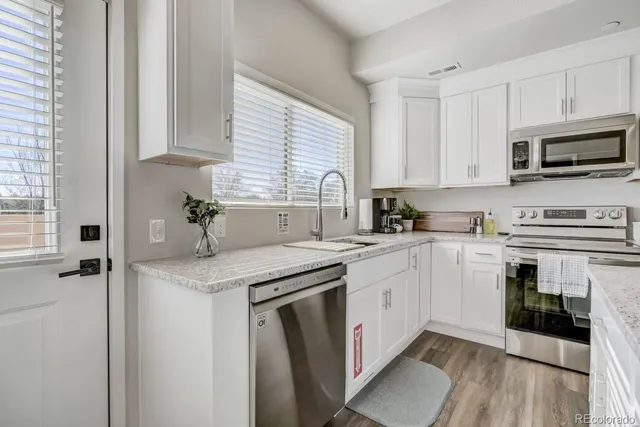 a bathroom with a granite countertop toilet and a sink