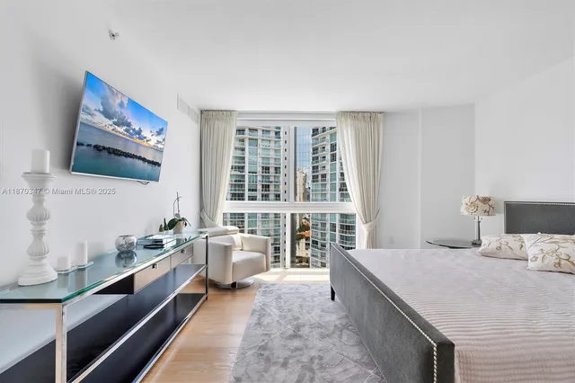 a large bedroom with a large bed and a flat screen tv