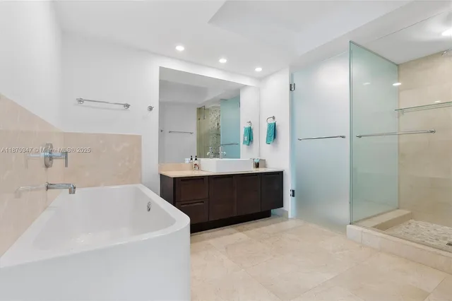 a bathroom with a bathtub sink mirror and shower