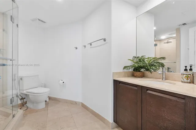 a bathroom with a sink a toilet and a large mirror
