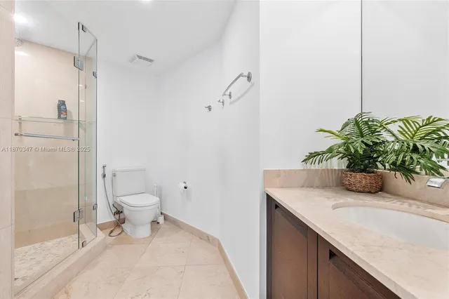 a bathroom with a granite countertop sink a toilet and shower