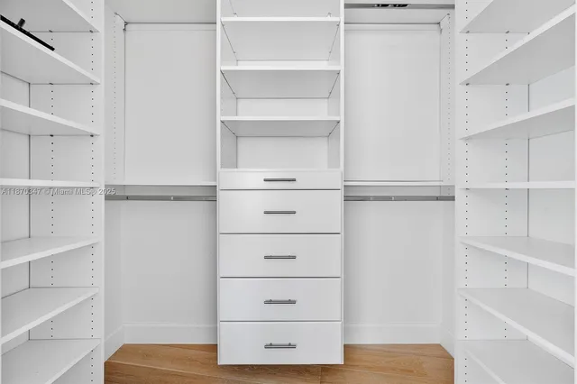 a view of walk in closet with empty racks