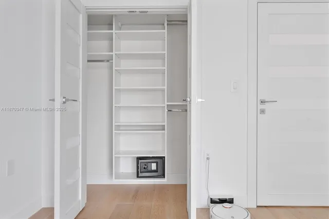a view of walk in closet with empty racks