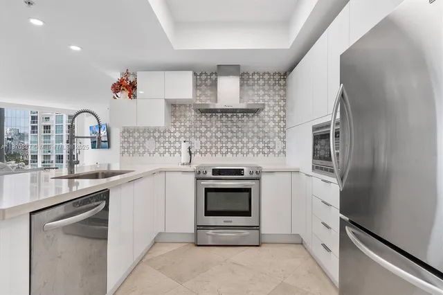 a kitchen with stainless steel appliances granite countertop a sink stove and refrigerator